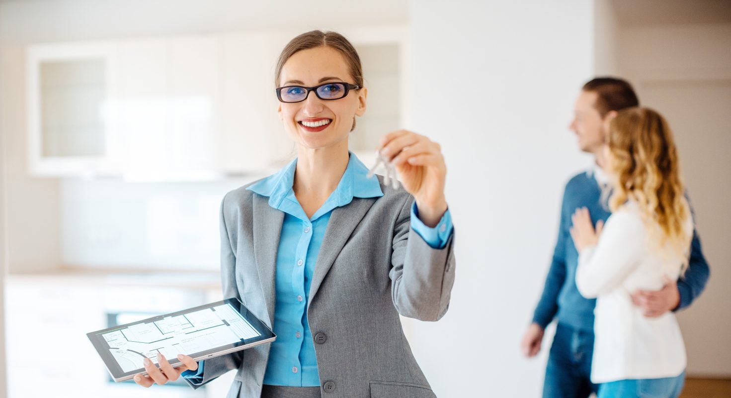 Portrait smiling real estate agent holding key