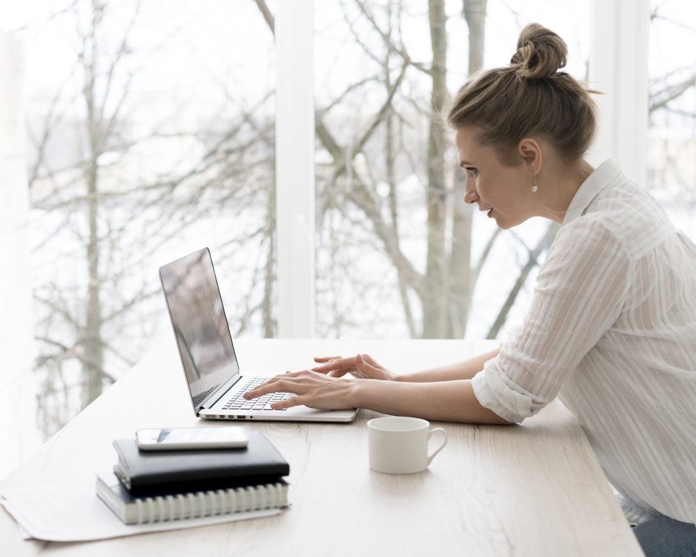 Side view woman working laptop