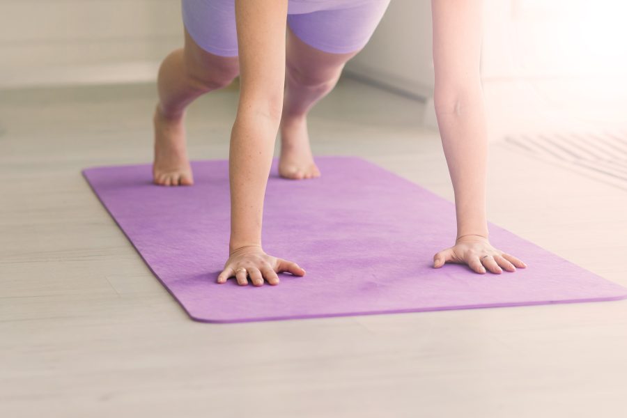 Health concept young beautiful woman does yoga exercise modern room