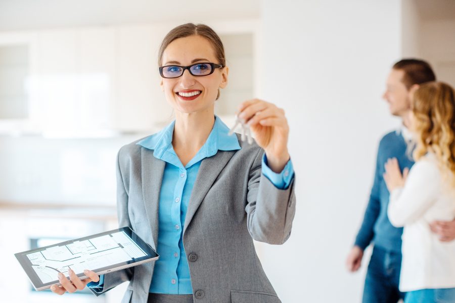 Portrait smiling real estate agent holding key