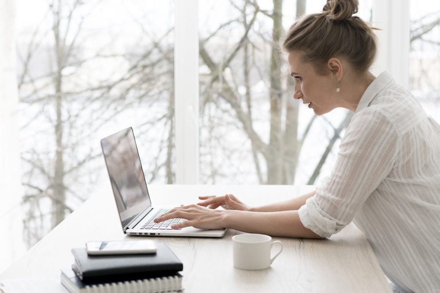 Side view woman working laptop