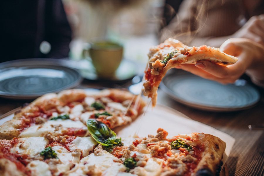 Three firends together eating pizza cafe copy