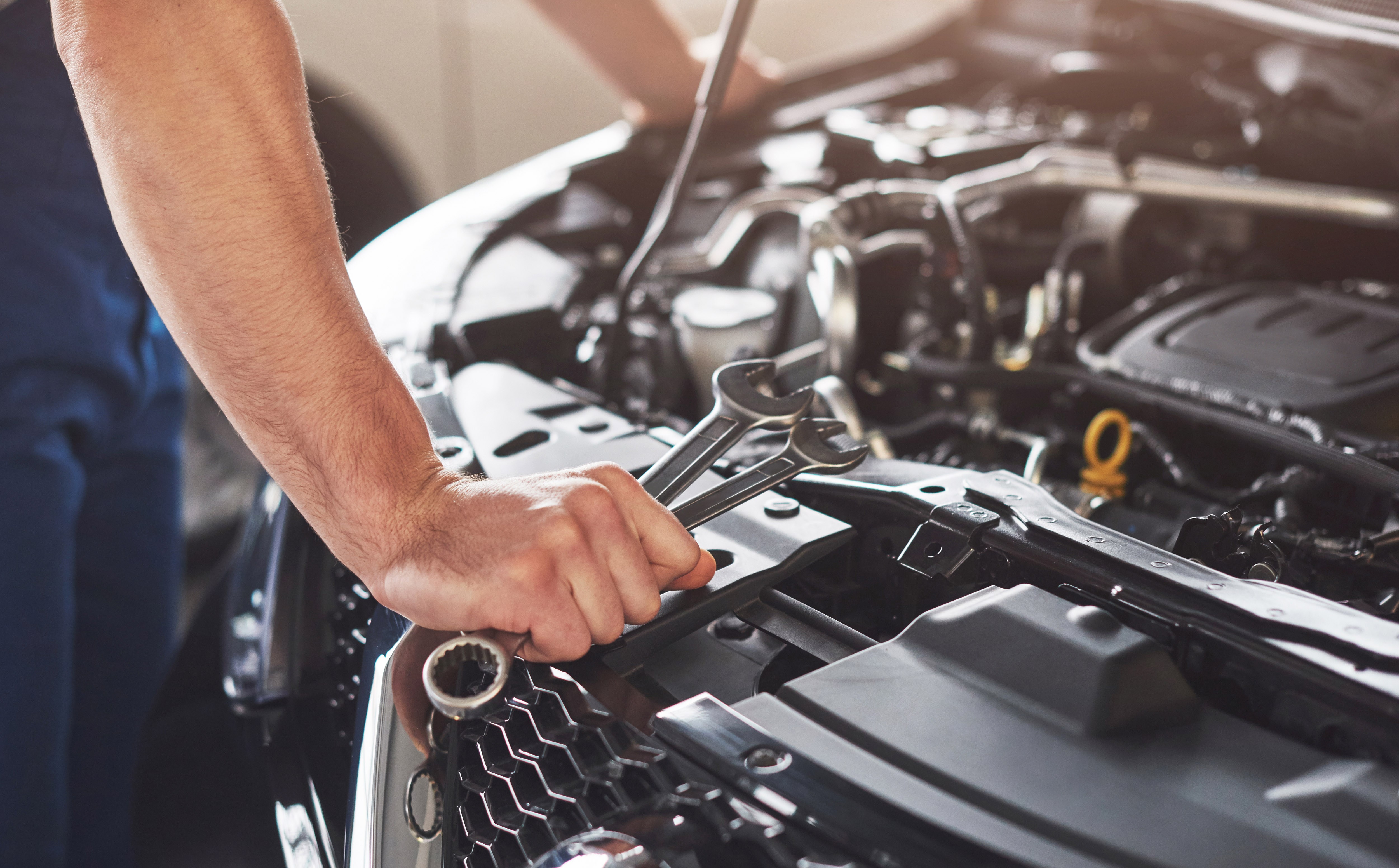 Muscular car service worker repairing vehicle 1