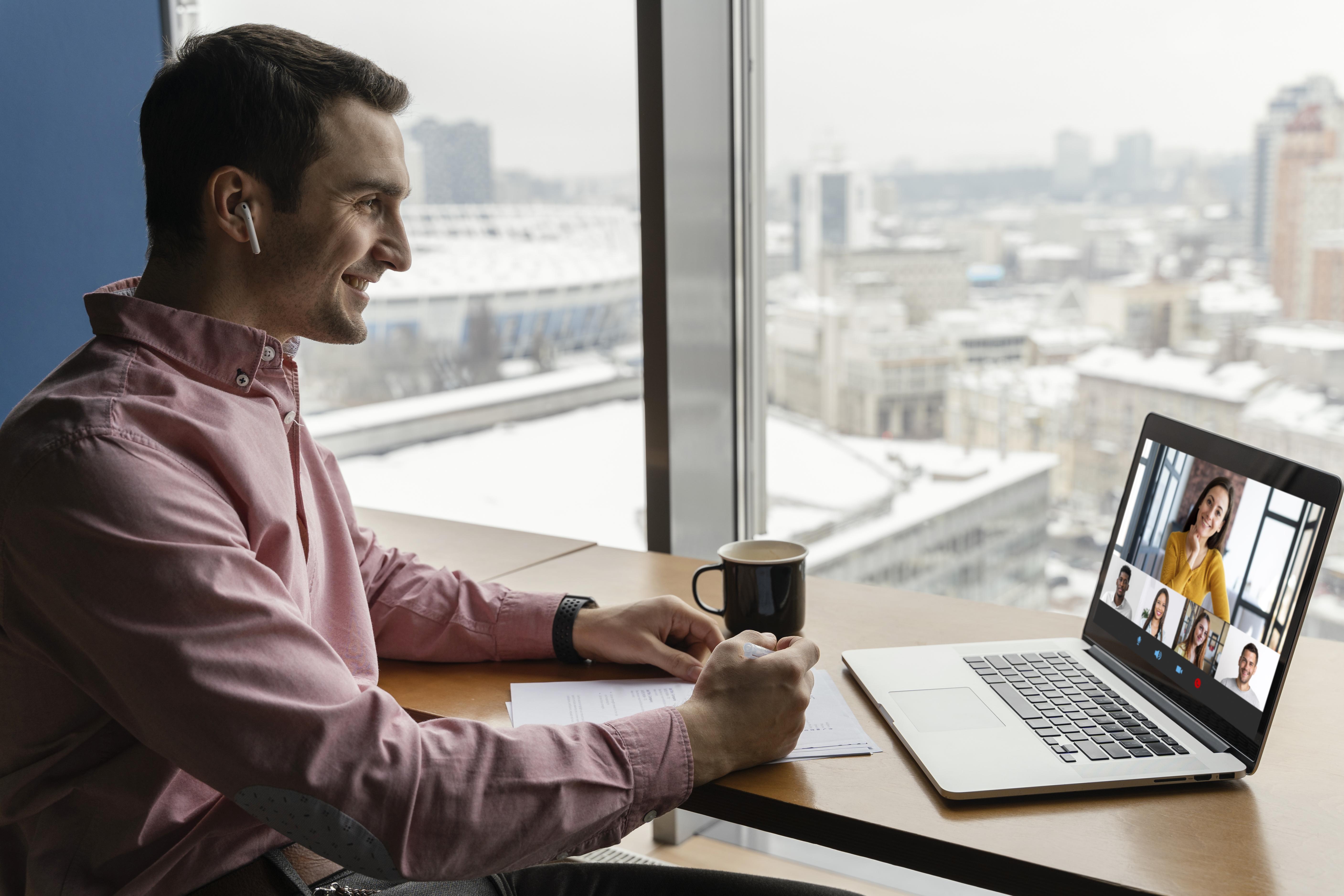 Side view man having online video call with coworkers